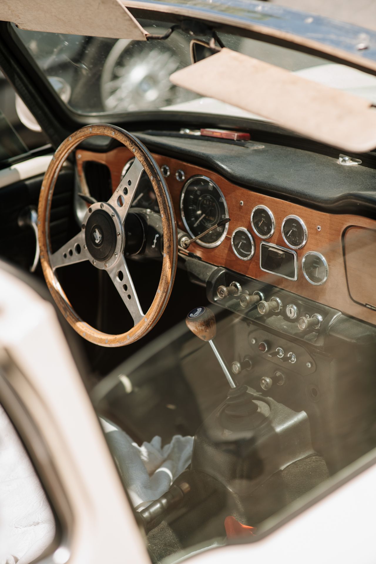 Interieur van een klassieke sportwagen met houten stuurwiel en originele klokken